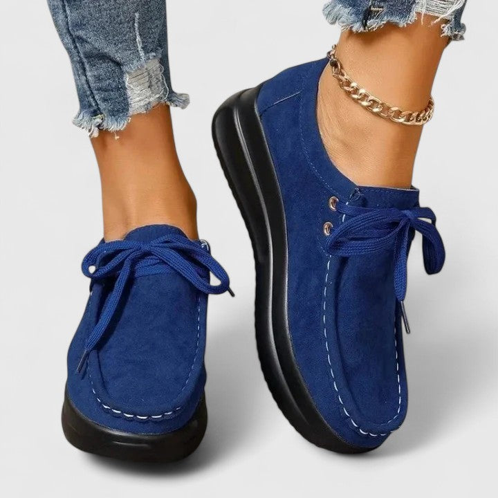 Blue lace-up orthopedic shoe with suede upper and thick black sole.