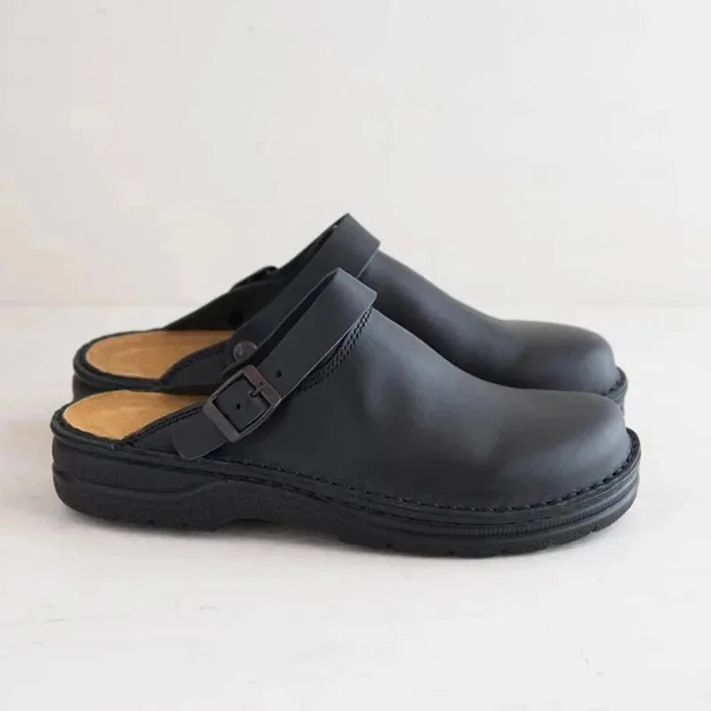 Black leather slide clogs with buckle strap and thick rubber sole