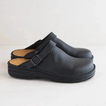 Black leather slide clogs with buckle strap and thick rubber sole