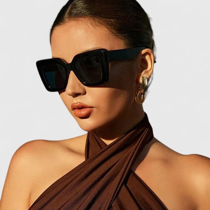 Black square sunglasses in side profile with dark lenses and thick frame