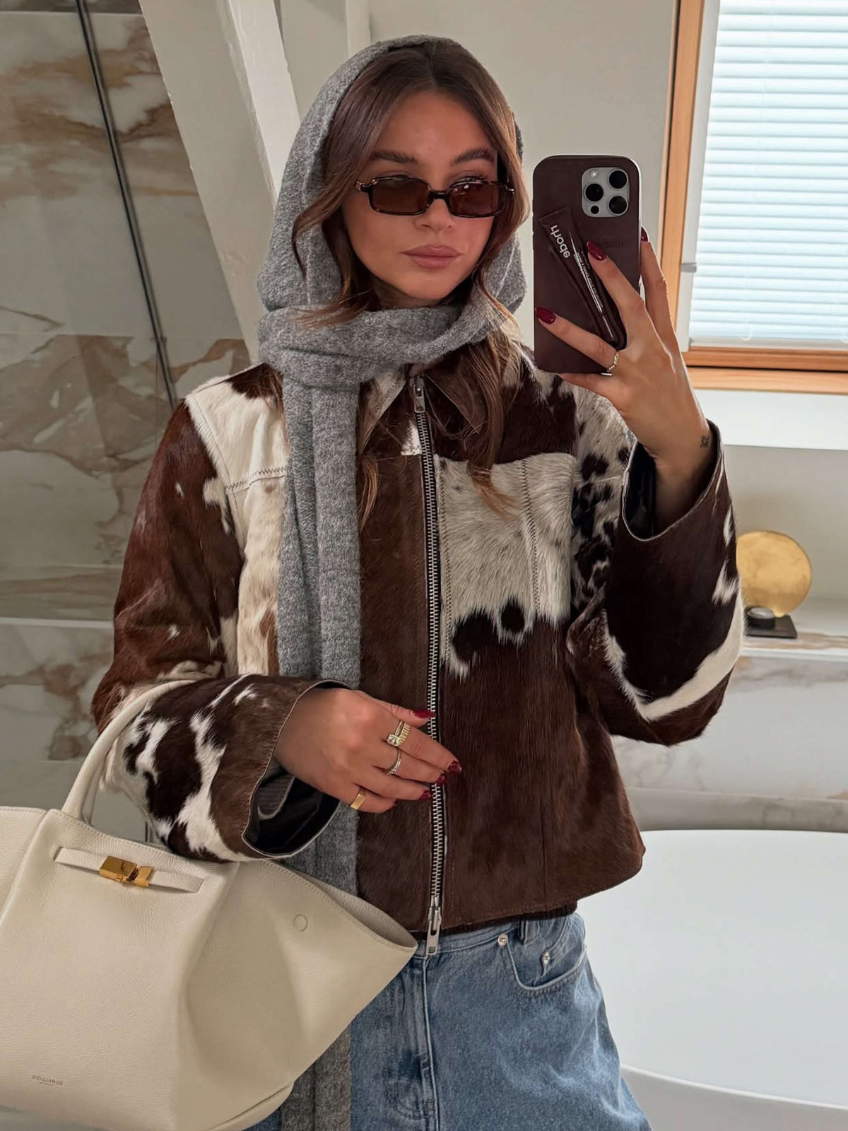 Dark square sunglasses with dark lenses, worn by a person indoors