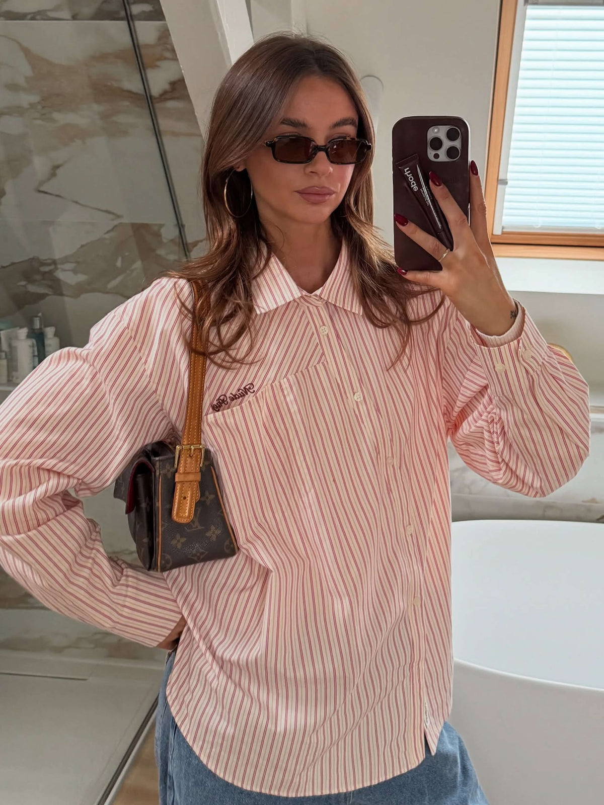 Black square sunglasses with dark lenses on a person posing indoors