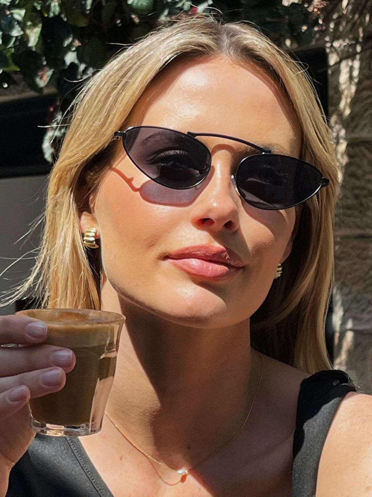 Black cat-eye sunglasses with dark lenses and thin metal arms