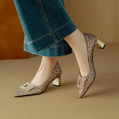 Gold-toned glitter pumps with pointed toe, jeweled bow detail, and low block heel