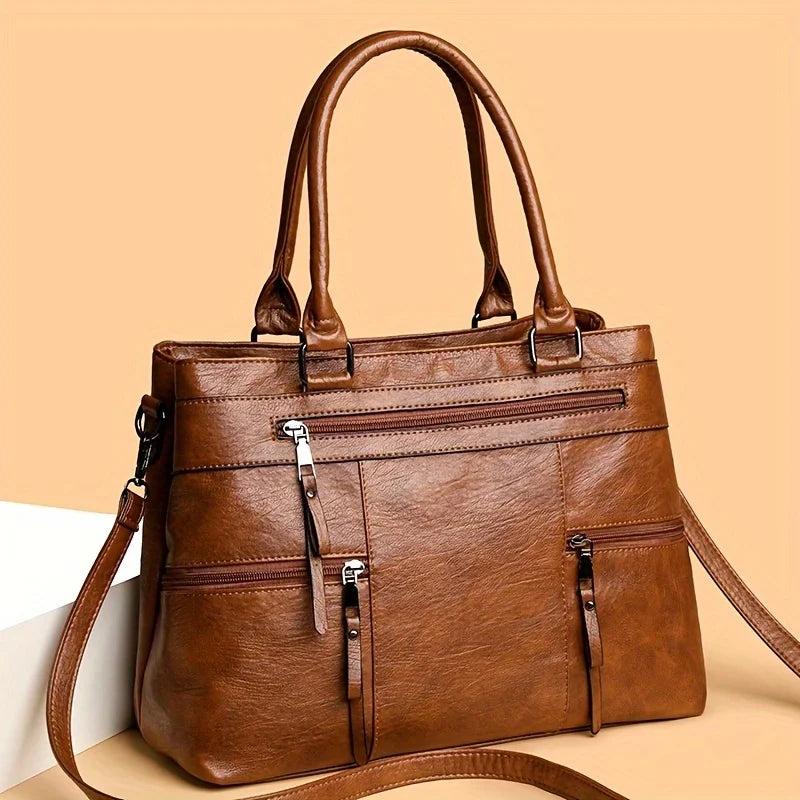 Caramel leather women’s tote bag with double handles, front zip pocket and crossbody strap