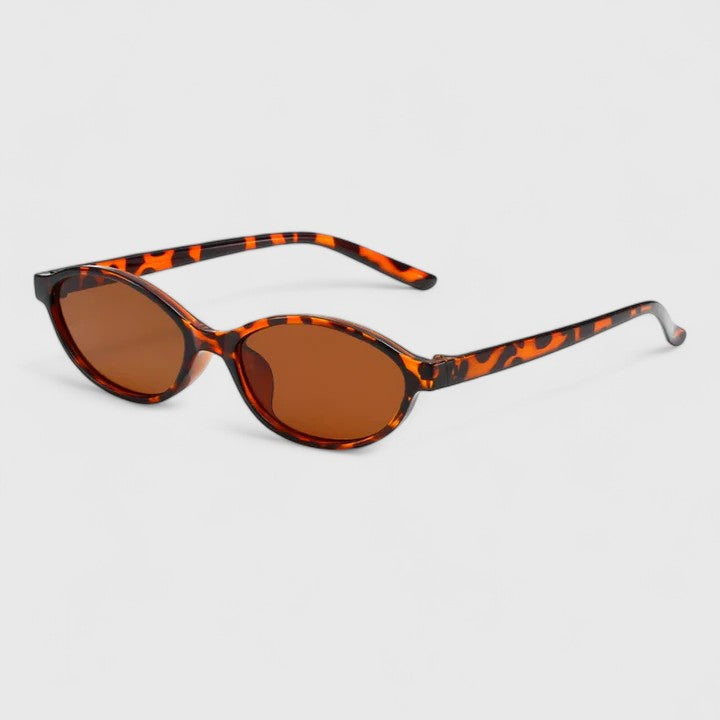 Sunglasses with leopard-print frames and amber lenses, rounded cat-eye shape