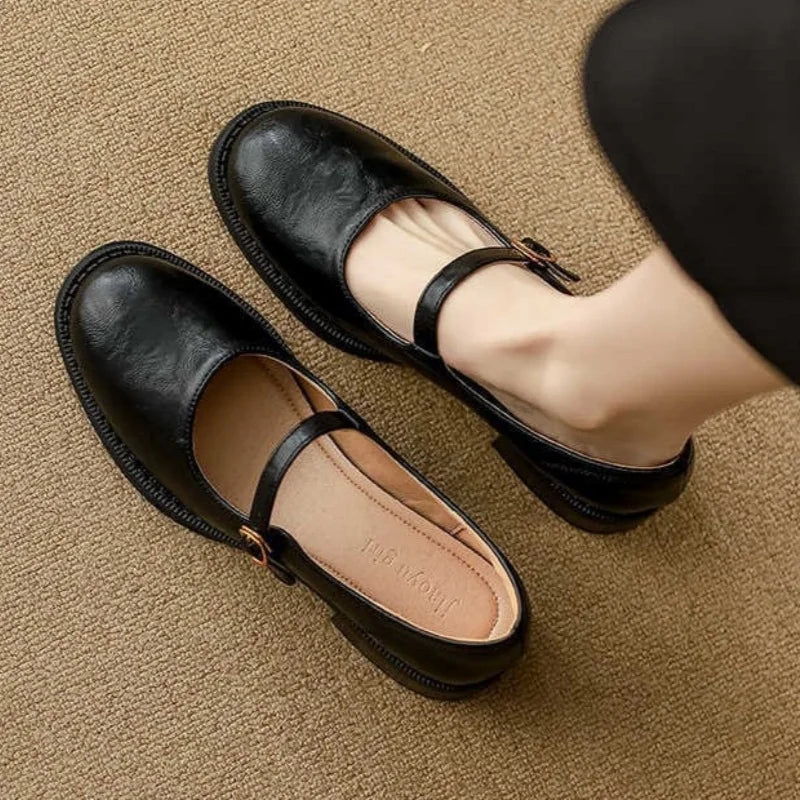 Leather Mary Jane shoes, black with ankle strap and buckle, rounded toe, low heel.