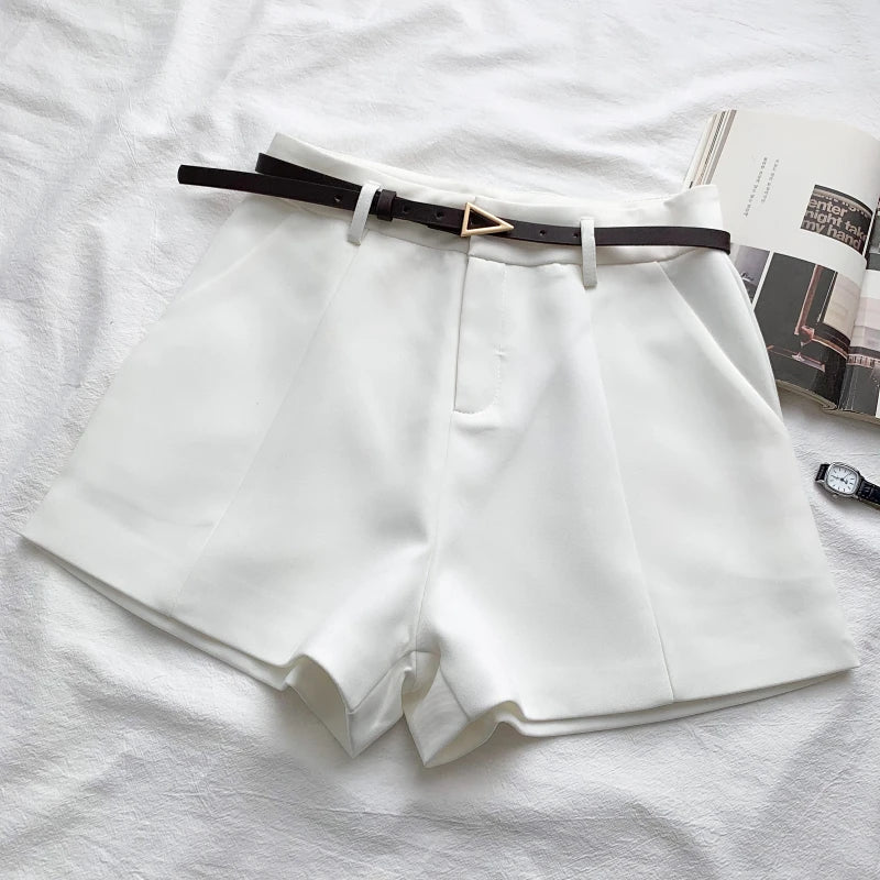 White high-waist shorts with front crease and faux leather belt with gold buckle