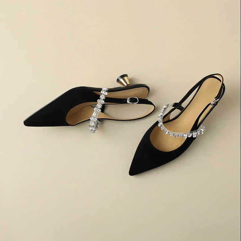 Black slingback pumps with rhinestone straps, pointed toes, and mid block heels