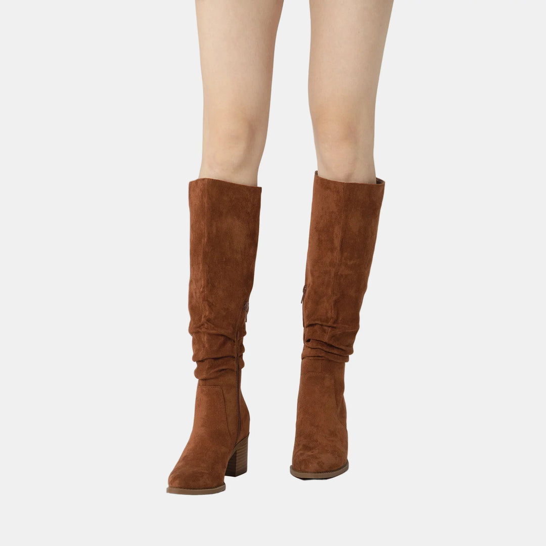 Brown suede knee-high boots with ruched shaft, side zip, and block heel