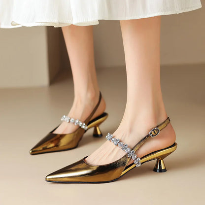 Gold pointed-toe slingback pumps with rhinestone straps and mid block heel