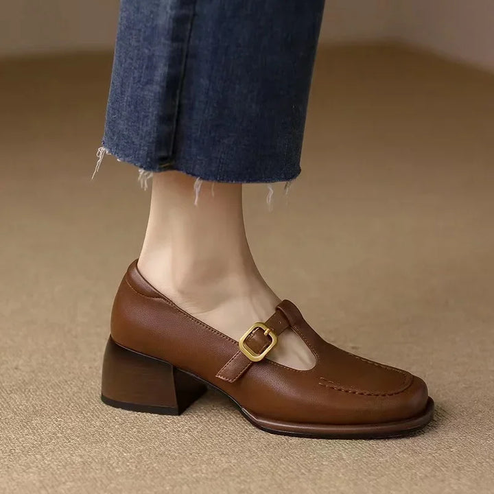 Brown T-strap heeled loafer with buckle strap and moccasin toe stitching