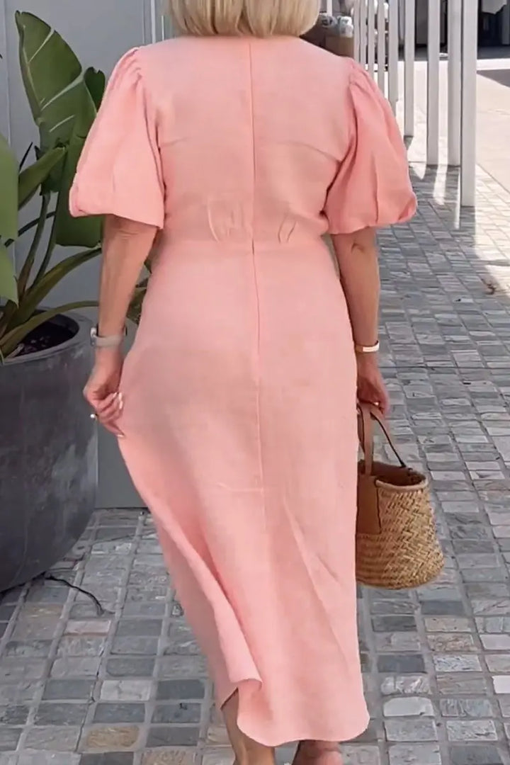 Peach V-neck midi dress with puff sleeves and tied waist, back view