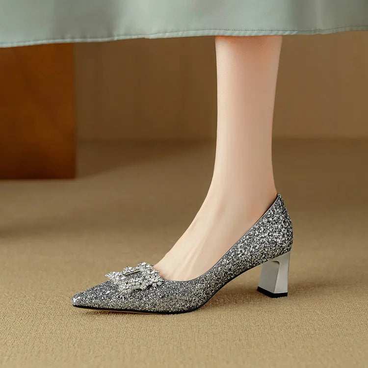 Silver-toned glitter pumps with pointed toe, jeweled bow, and chunky block heel