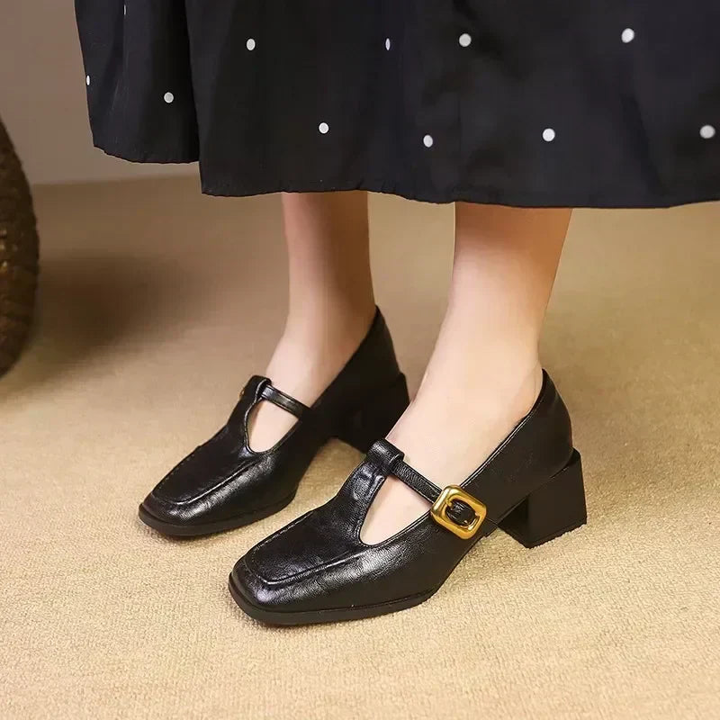 Black Mary Jane pumps with square toe, T-strap, and gold buckle block heel