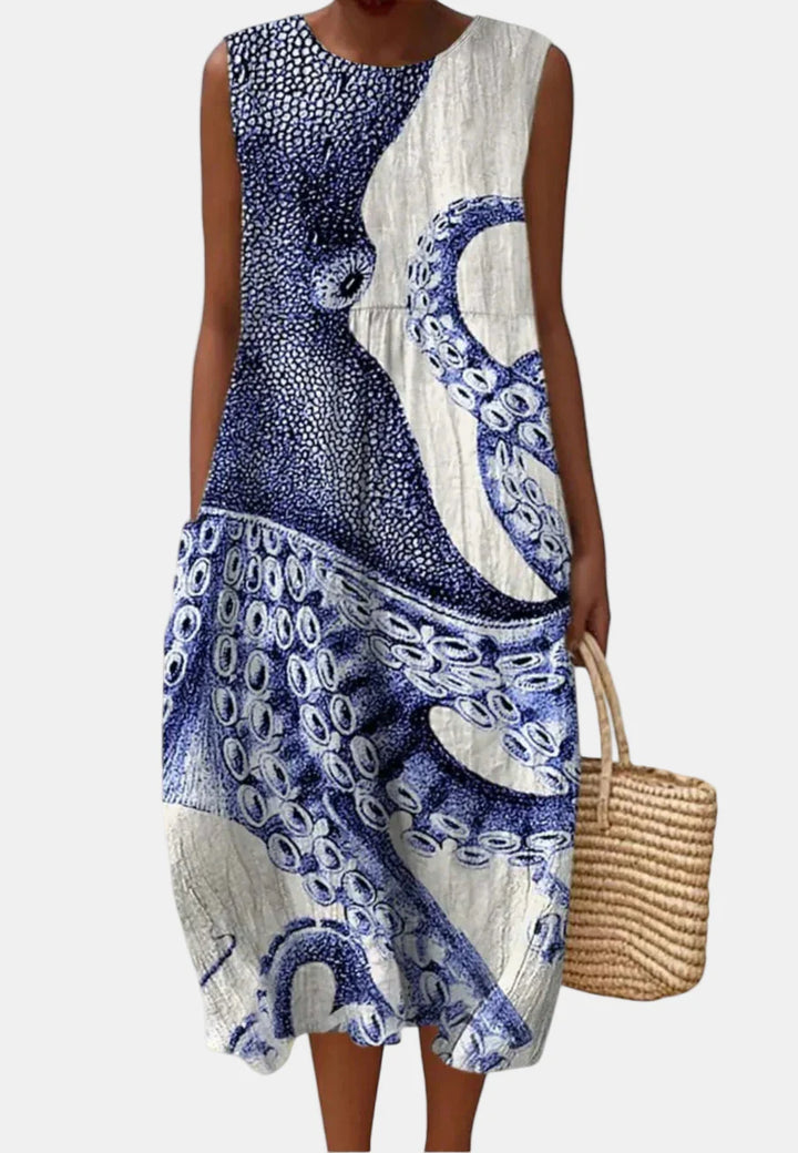 Sleeveless ocean blue and white patterned dress with round neck and draped front panel