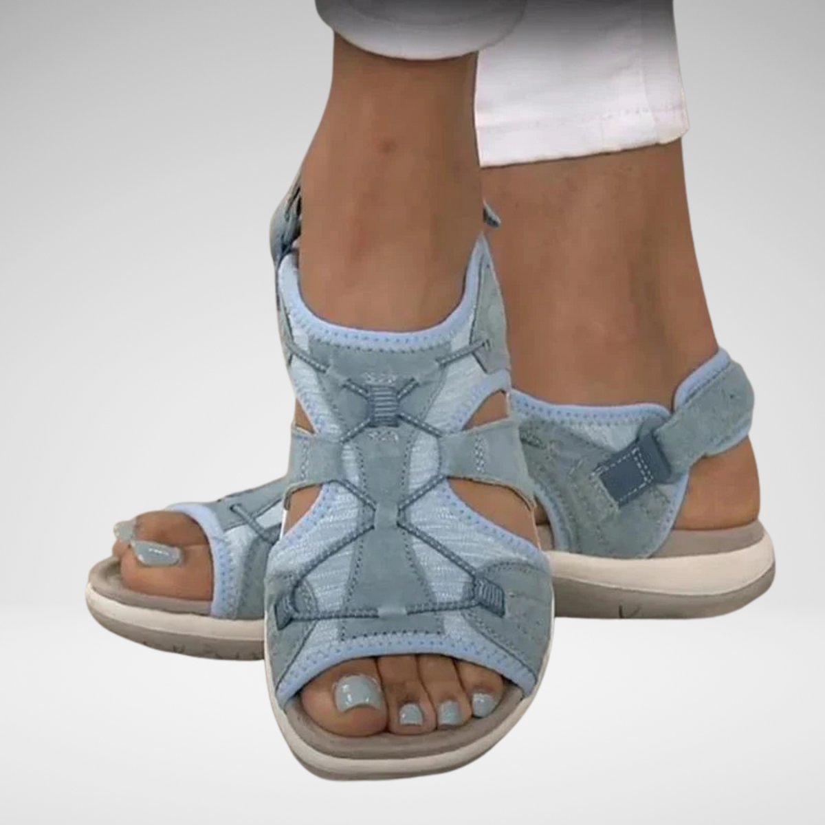 Light blue orthopaedic sandals with cross straps, buckle detail, and cushioned sole