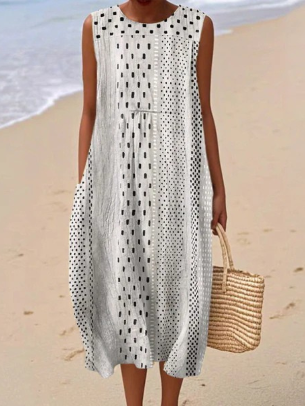 Sleeveless midi dress with black polka dot pattern and round neckline, sleeveless