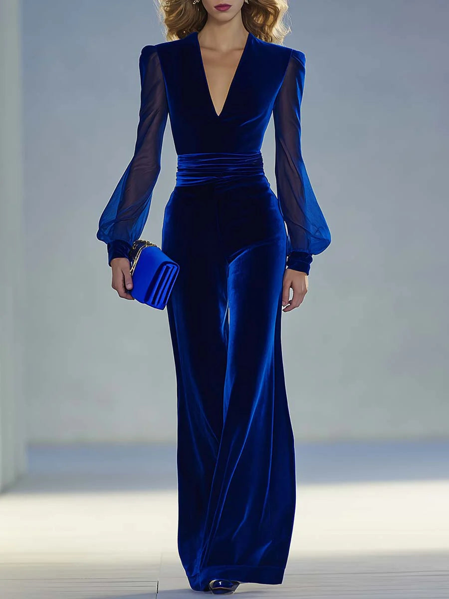 Blue suede V-neck jumpsuit with long fitted sleeves and pleated waist seams