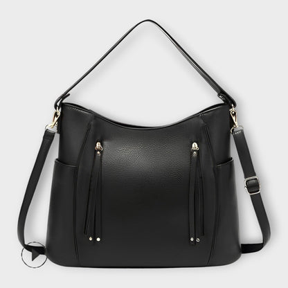 Black leather hobo handbag with zip front and tassel details, plus shoulder straps.