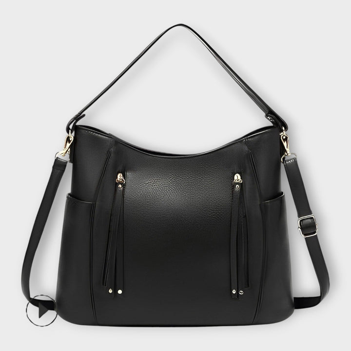 Black leather hobo handbag with zip front and tassel details, plus shoulder straps.