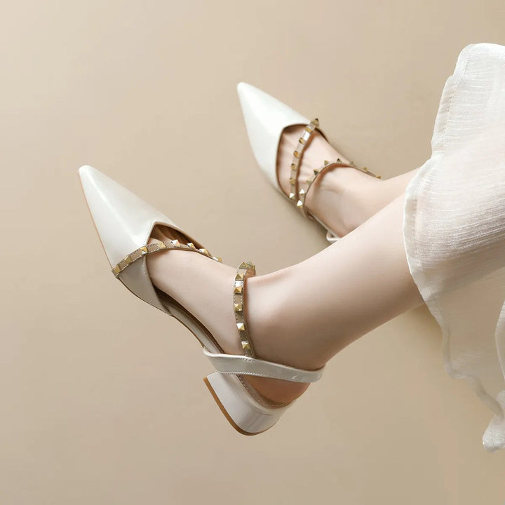 Beige orthopedic heels with pointed toe, strappy design, and gold-tone stud trim