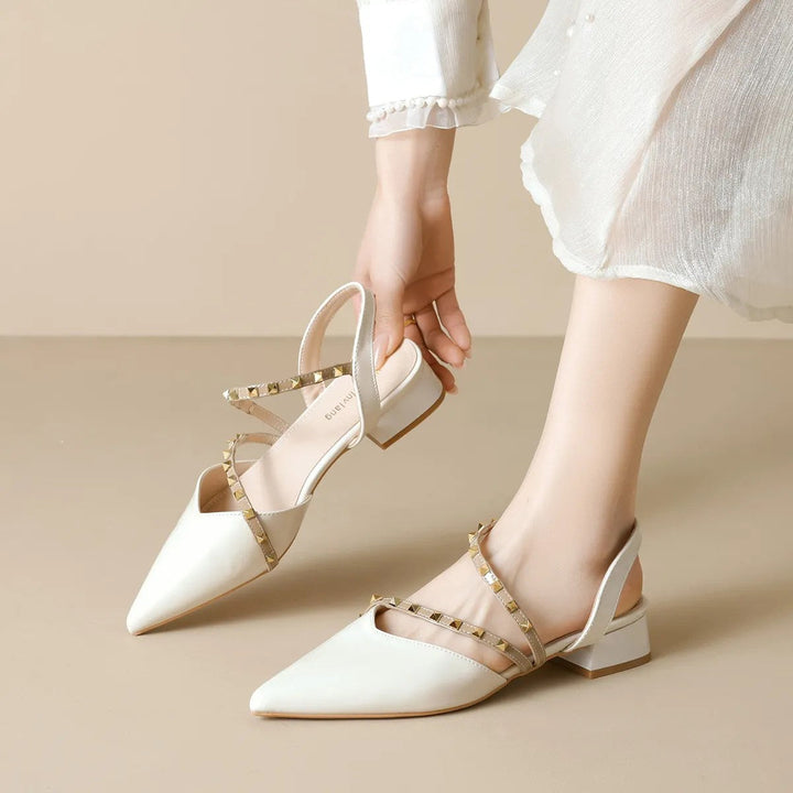 Beige orthopedic heels with ankle slingback strap and gold-tone stud trim, side view