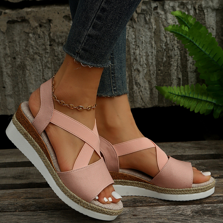 Pink canvas espadrille platform sandals with crossed toe straps and ankle bracelet