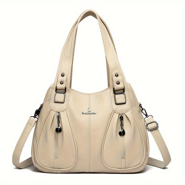 Women’s casual shoulder bag in cream with top handles and adjustable shoulder strap.