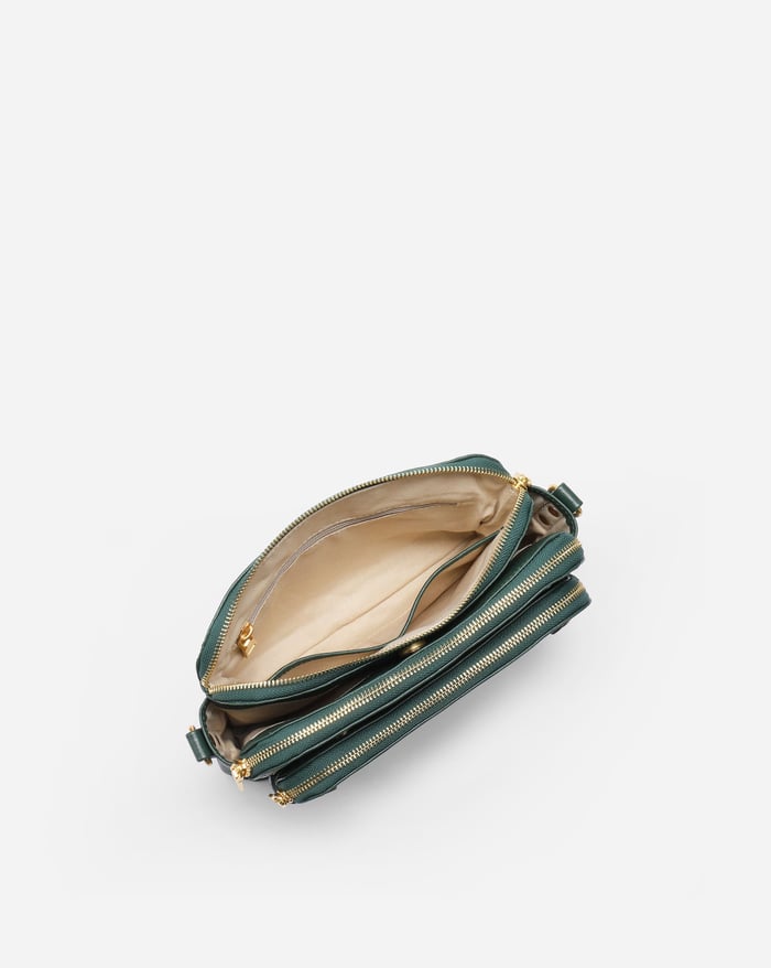 Jovie deep green crossbody bag, open interior with beige lining and zip-top closure