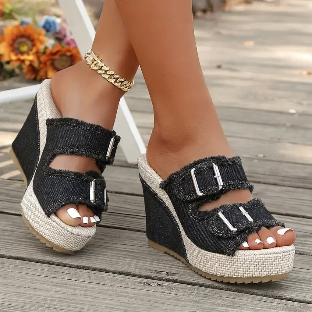 Black wedge sandals with two buckle straps, open toe, and textured espadrille platform