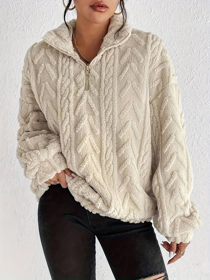 Warm knit quarter-zip sweater in cream with cable texture and stand collar.