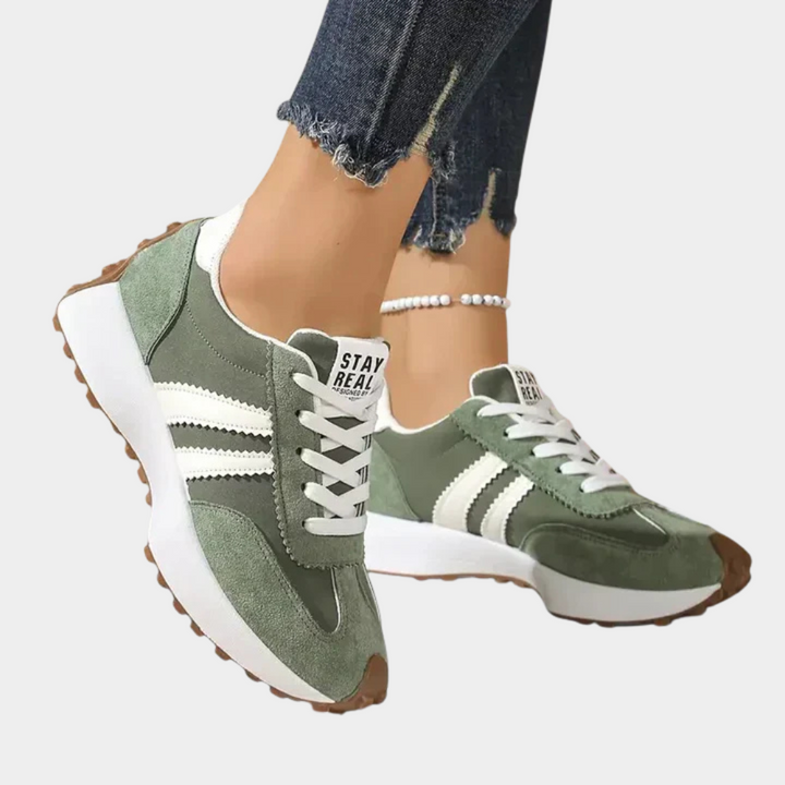 Green low-top lace-up orthopedic sneakers with white triple stripes and chunky cushioned sole