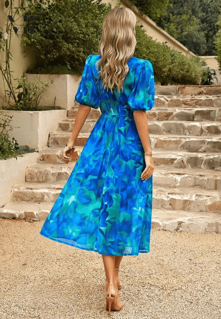 Blue abstract midi dress with puff sleeves and gathered waist, shown from back