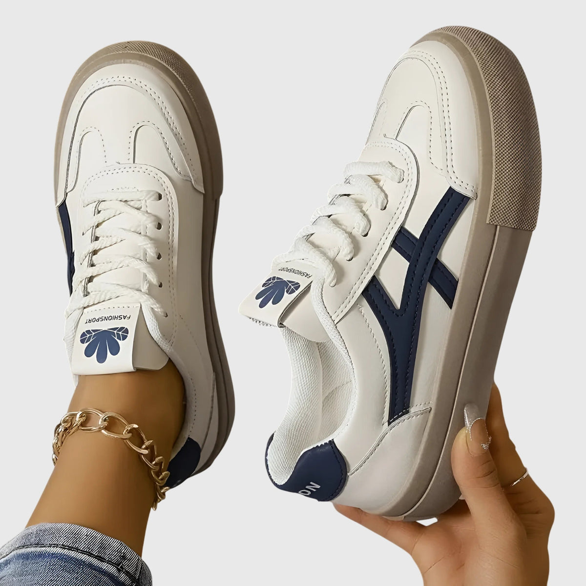 White orthopedic sneakers with navy side stripes and tan platform sole, front lace-up