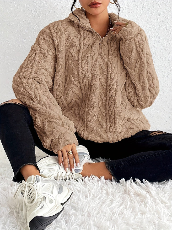 Warm knit quarter-zip sweater in tan with cable texture, long sleeves, stand collar.