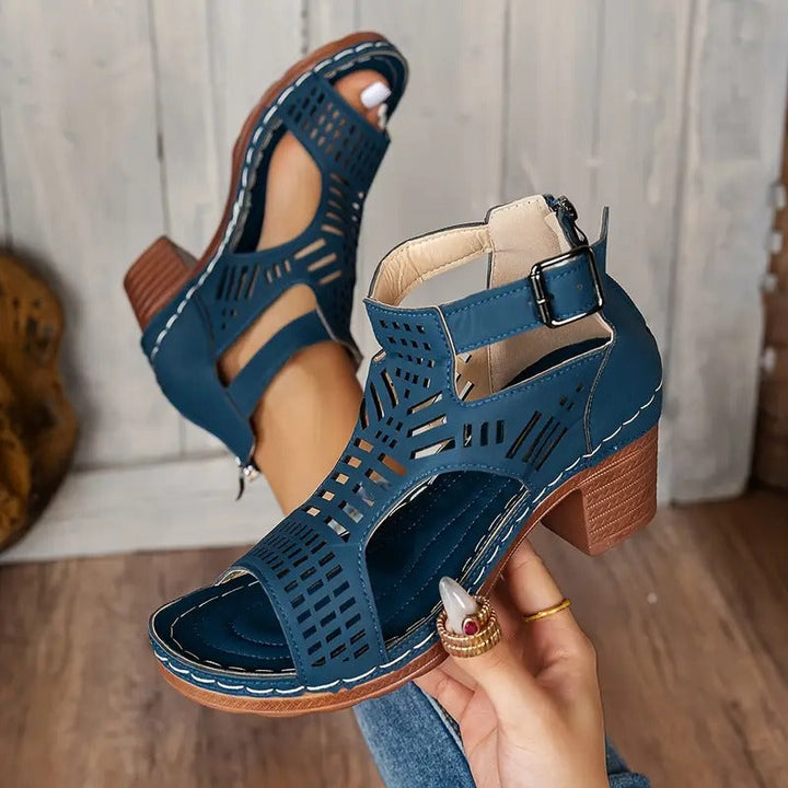 Navy blue ergonomic sandals with ankle strap, peep-toe cutouts, and stacked heel