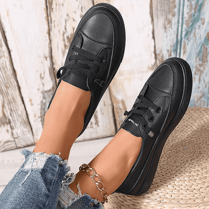 Black lace-up sneakers with smooth leather-like upper and sturdy rubber sole
