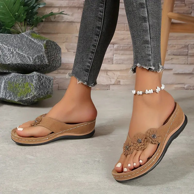 Tan orthopedic sandals with embossed flower details, contrast stitching, and cushioned sole