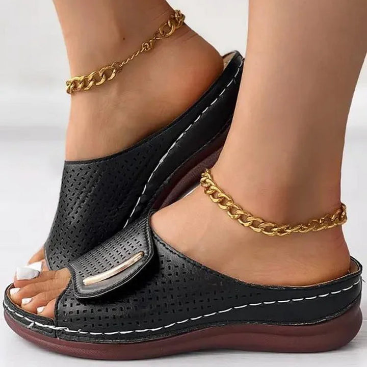 Perforated slide sandals in black with metal-look accent and cushioned sole