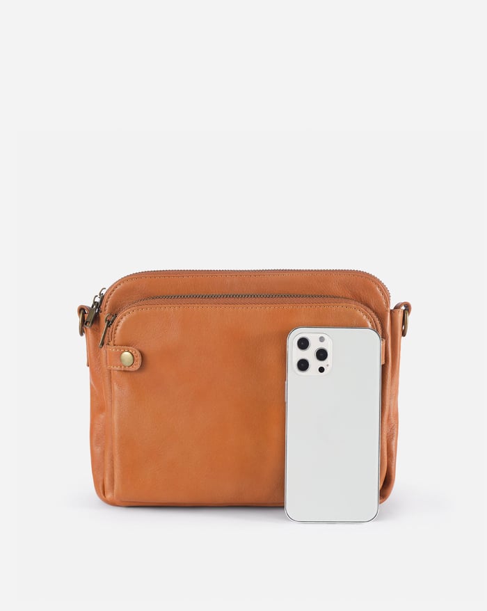 Jovie sleek three-layer crossbody bag in tan-brown with zip top; phone fits inside