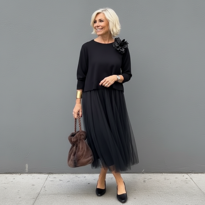 Black knit layered dress set with elbow-length sleeves, flower detail, and pleated midi skirt