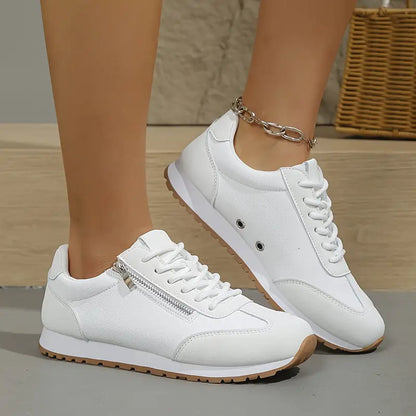 All-white casual sneakers, lace-up with side zipper and ankle chain, gum sole.