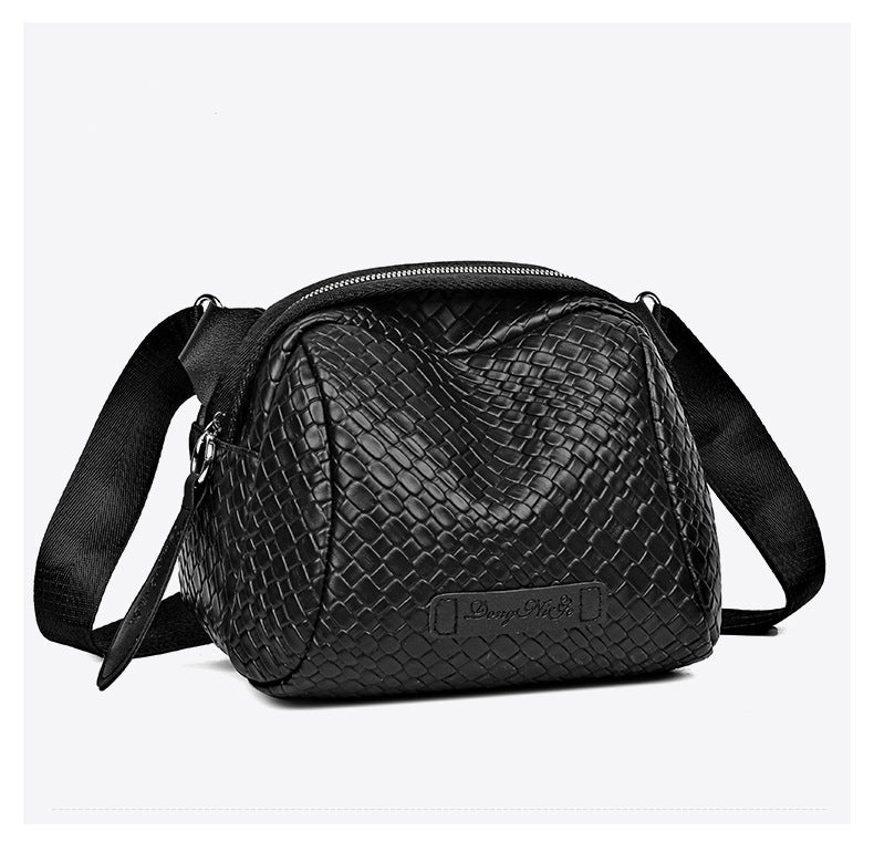 Black woven-texture shell crossbody bag with zip top and front logo patch