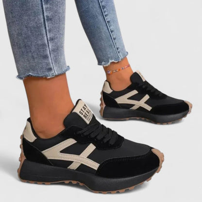 Black cloud sneakers with cream stripes, lace-up front and thick rubber tread sole