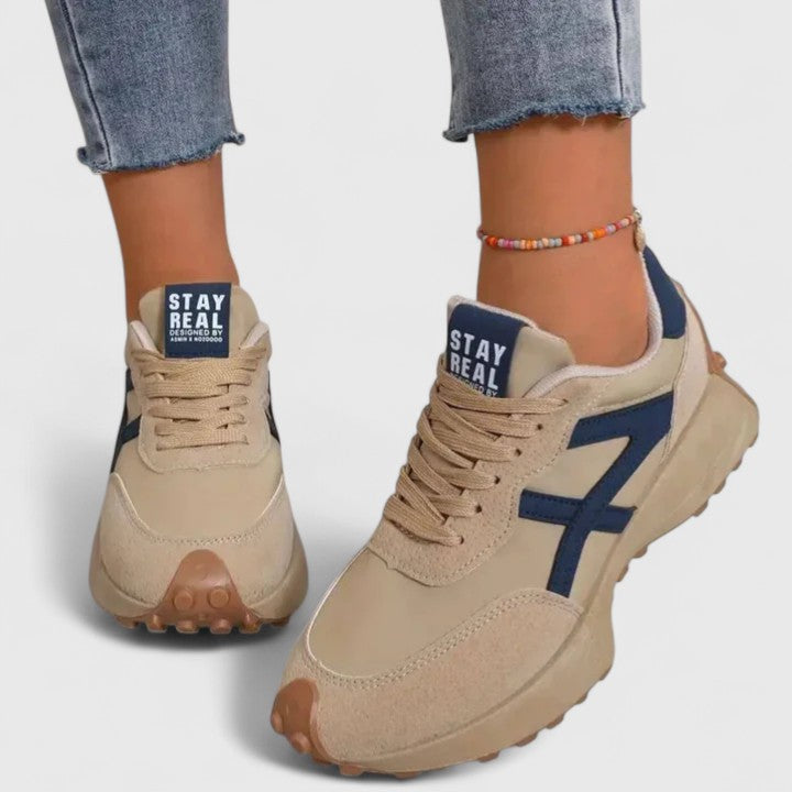 Beige cloud sneakers with navy side panels, lace-up front and chunky tread sole