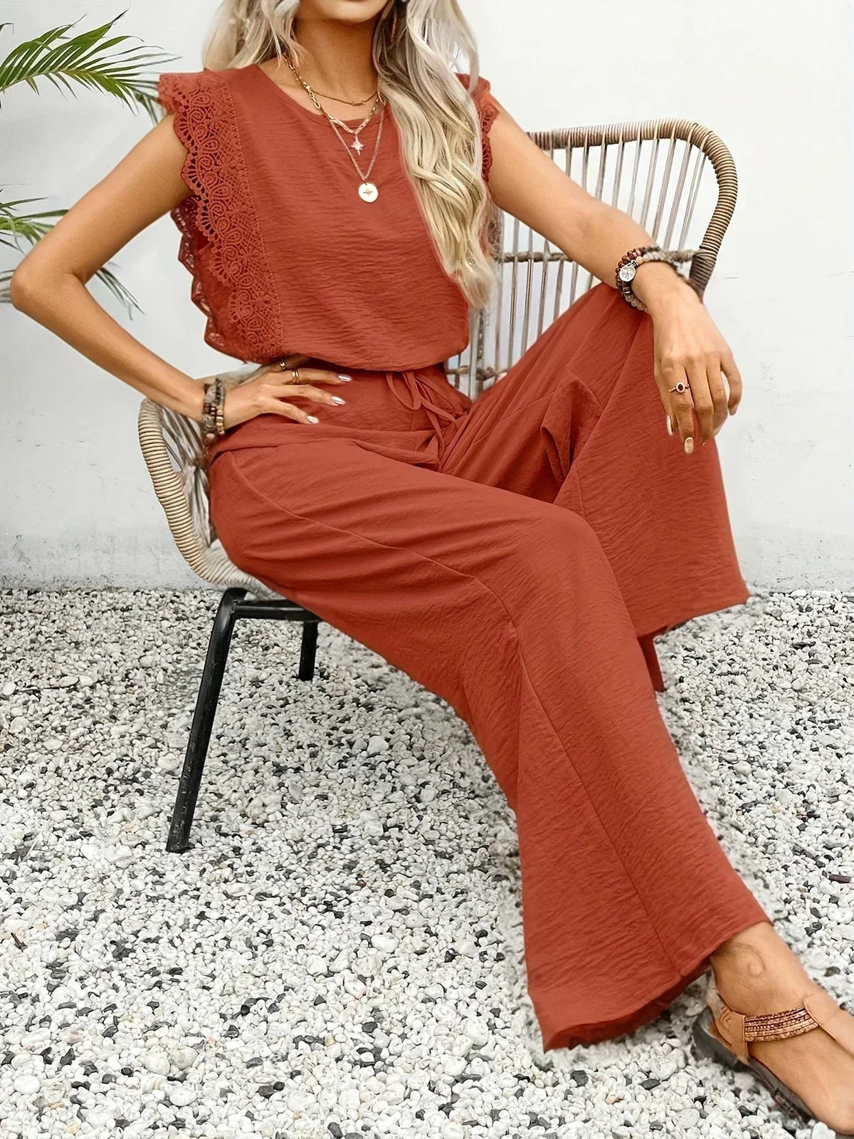 Two-piece set in rust red: lace-trim sleeveless top and flowing wide-leg trousers