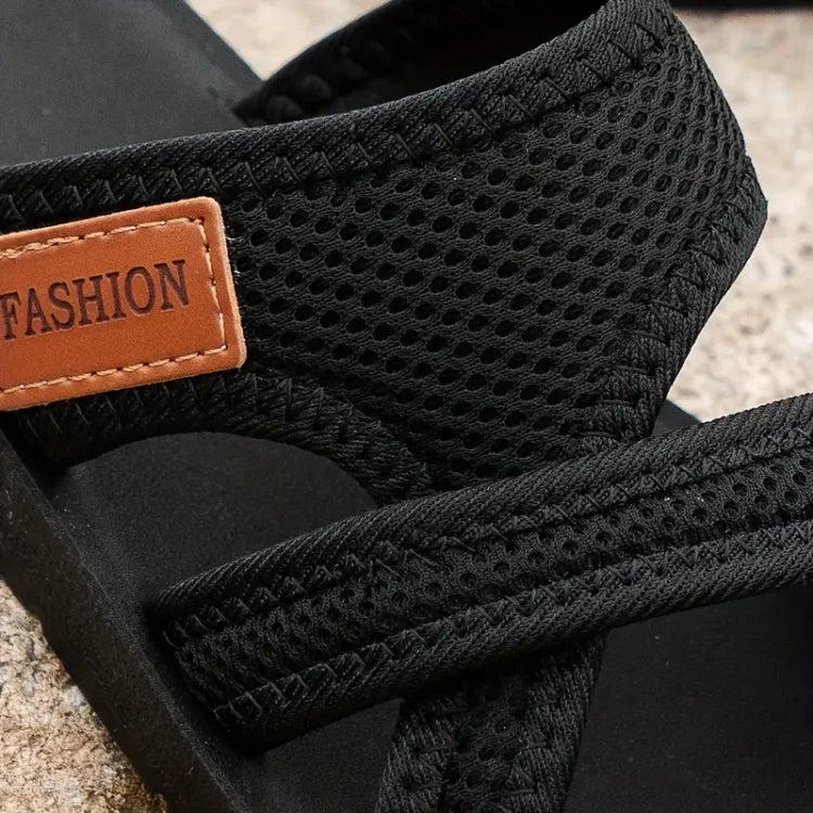 Black bunion corrector slide sandal close-up: mesh strap and stitched toe area