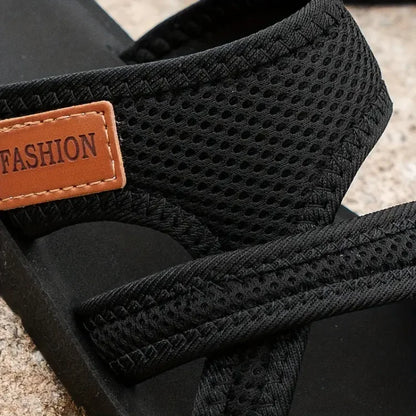 Black bunion corrector slide sandal close-up: mesh strap and stitched toe area