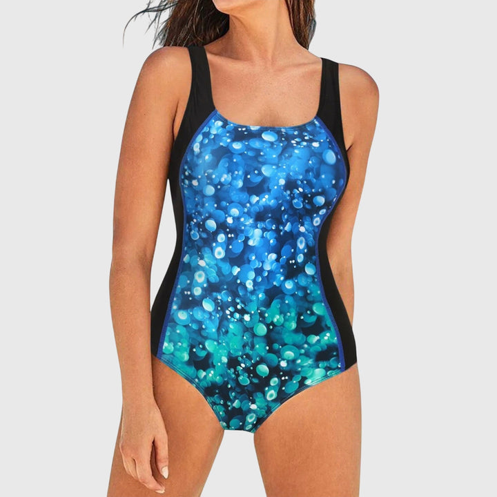 Shaping swimsuit with blue bubble-dot print on black, scoop neckline
